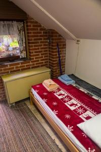 una camera con un letto con una coperta rossa di Zimska idila a Crni Vrh