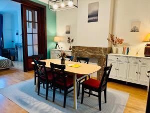 een eetkamer met een tafel en stoelen en een open haard bij Cozy, comfortable apt, well located - EU ULB VUB in Brussel +12 foto's