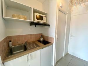 a kitchen with a sink and a microwave at Studio calme -304- in Canet-en-Roussillon