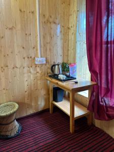 ein Holztisch mit einem Topf darauf in einem Zimmer in der Unterkunft Parashar lake Fogg hill Resort in Prashar lake