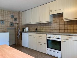 a kitchen with white cabinets and a stove top oven at Revier Bliili und Spitzer in Diesbach +19 photos
