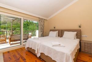 a bedroom with a large bed and a balcony at Doğa Manzaralı Kiralık Villa in Bezirgân +36 photos