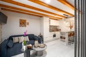 a living room with a blue couch and a kitchen at Cozy Studio-Apartment inmitten der Altstadt von Porec und nur 50 Meter zur Adria in Poreč