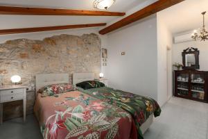 a bedroom with a bed and a stone wall at Cozy Studio-Apartment inmitten der Altstadt von Porec und nur 50 Meter zur Adria in Poreč