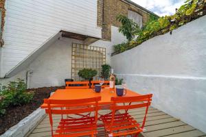 an orange table and chairs on a patio at Ramsgate Family Cottage nr Beach -Harbour- Sleeps 4 - Garden - Parking on Street in Ramsgate +52 photos