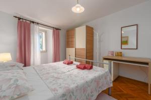 a bedroom with a bed with two red pillows on it at Strandnahes Apartment inmitten der Altstadt mit mediterranem Garten - nur 150 Meter zum Meer in Poreč