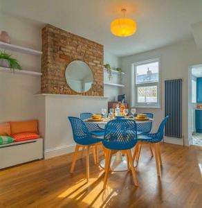 a dining room with a table and blue chairs at Ramsgate Family Cottage nr Beach -Harbour- Sleeps 4 - Garden - Parking on Street in Ramsgate
