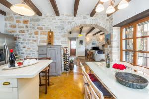 a kitchen with a stone wall and a table with chairs at Beeindruckende Finca mit Privatpool, Meerblick, Babybett und besonderem Interieur in Vošteni