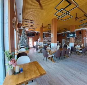 a restaurant with tables and chairs and a christmas tree at Cave Beach Resort - Boutique Accomodation in Dingalan