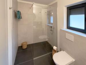 a bathroom with a toilet and a shower at Villa Ena in a peaceful location with a sea view in Zagorje +8 photos