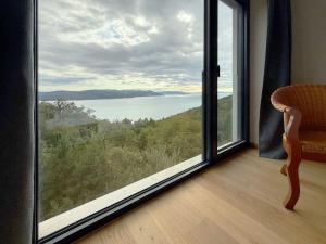 a room with a large window looking out at a lake at Villa Ena in a peaceful location with a sea view in Zagorje