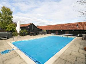 a swimming pool in a courtyard with a house at Rough Hill House in Chelmsford