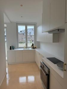 a white kitchen with a sink and a window at Appartement neuf en plein centre in Namur