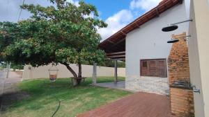 a house with a tree in the yard at Casa Portal das Flecheiras in Trairi