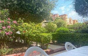 a table and chairs in a garden with pink flowers at Gorgeous Home In Malaga in Málaga +31 photos