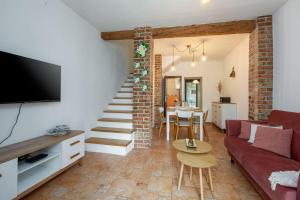 a living room with a red couch and a staircase at Strandnahes Apartment inmitten der Altstadt mit mediterranem Garten - nur 150 Meter zum Meer in Poreč