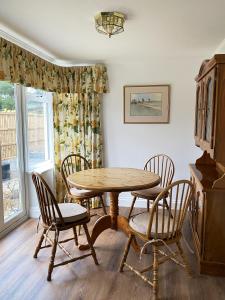 a dining room with a table and chairs and a window at Garden Cottage in Great Yarmouth