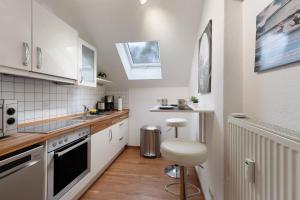 una cocina con armarios blancos y taburete. en Tifra-living, en Hardenberg