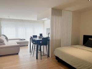 una camera da letto con un letto, un tavolo e un divano di Ruime, rustige studio centrum Oostende a Ostenda