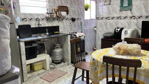 a small kitchen with a table and a kitchen with a sink at SUITE banheiro privativo & 2 QUARTOS banheiro social PERTO DO GERALDÃO,ARENA PERNAMBUCO,UNIVERSO, UFPE,AEROPORTO-AFOGADOS- RECIFE in Recife