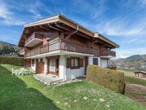 a house with a balcony on top of a field at Confortable 3 pièces avec animaux admis à Megève Jaillet - FR-1-453-38 in Megève
