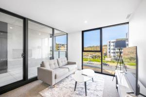 a living room with a couch and a table at Modern Homy 1B1B APT Pool Gym Cinema Westfield Cafe in Phillip