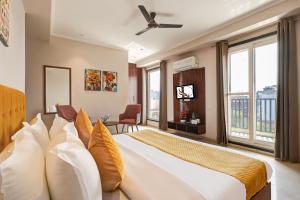 een slaapkamer met een groot bed met gele en witte kussens bij Limewood Stay Oasis - Golf Course Road in Gurgaon