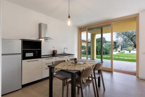 Una cocina con una mesa con sillas y un refrigerador. en Agriturismo Le Campagnole Pink, en Bardolino