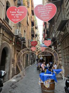 una strada con un gruppo di cartelli appesi agli edifici di Esposito Holiday homes a Napoli