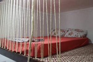a bedroom with a bed with a hanging bed frame at Kitnet MiniHouse do Alto in Lençóis