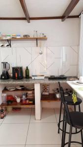 a kitchen with a counter with two chairs in it at Kitnet MiniHouse do Alto in Lençóis +21 photos