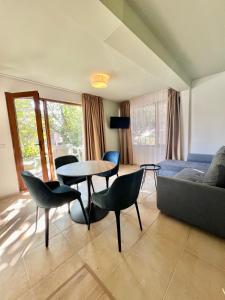 a living room with a couch and a table and chairs at Kiara Apartments in Saints Constantine and Helena
