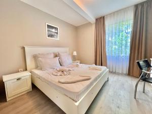 a white bed in a room with a window at Kiara Apartments in Saints Constantine and Helena +133 photos