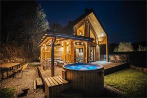 a large hot tub in front of a log cabin at CzillChata - dom z balią in Maków Podhalański