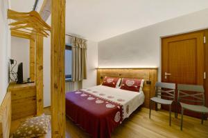 a bedroom with a bed and a table and chairs at Agriturismo La Grange in Pont-Saint-Martin