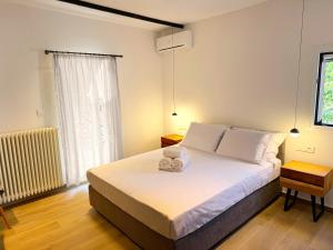 una camera da letto con un letto con lenzuola bianche e una finestra di Grouspa Oiti a Oíti