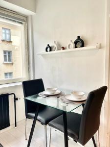 Un comedor con una mesa y dos sillas. en Puma's central flat 2 in Helsinki, en Helsinki