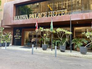 カイロにあるMarwa Palace Hotel Cairoの旗と植物が目の前にある建物