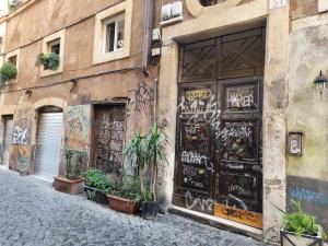a street with graffiti on the side of a building at Casa Ludovica Trastevere in Rome