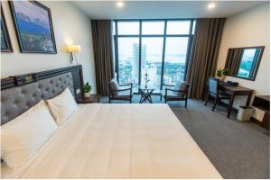 a hotel room with a large bed and a desk at Peace Hotel Hạ Long in Ha Long