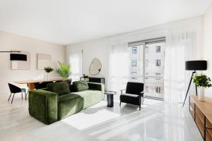 a living room with a green couch and a table at RELSTAY - Montenapoleone in Milan