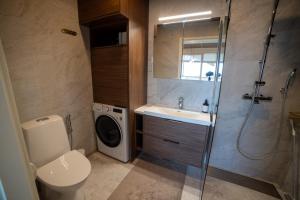 une salle de bain avec un lavabo et une douche dans l'établissement Marina Resort C9, à Kalajoki 6 autres photos