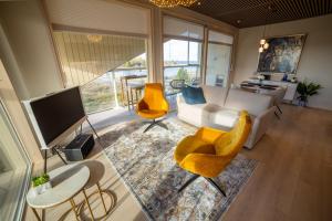 un salon avec un canapé blanc et des chaises jaunes dans l'établissement Marina Resort C9, à Kalajoki