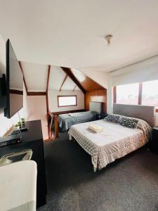 a bedroom with two beds and a desk and a television at MONTERRICO POLO APARTS #4 - Dpto Completo Familiar 2 camas a una cuadra Embajada USA in Lima