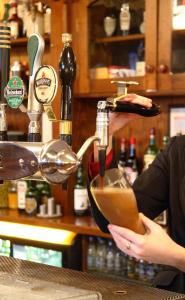 a woman is pouring a drink into a mixing bowl at Killarney Riverside Hotel in Killarney