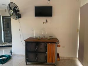 Zimmer mit einem TV an der Wand und einem Schrank in der Unterkunft Casa en Yanda, sobre Ruta Nacional 9, salida directa Autódromo in Zanjón