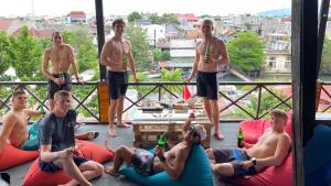 a group of men sitting on bean bags on a balcony at Evergreen Lodge in Padang