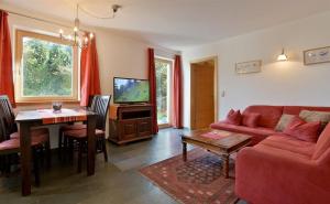 瑟尔Bichler Katrin, Ferienwohnung的客厅里有一张红色的沙发和一张桌子
