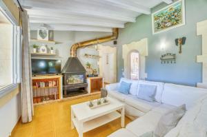 salon z białą kanapą i telewizorem w obiekcie Ideal Property Mallorca - Can Caragol Font de Sa Cala w mieście Capdepera