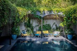 a patio with chairs and an umbrella next to a pool at Hôtel Ville d'Hiver in Arcachon